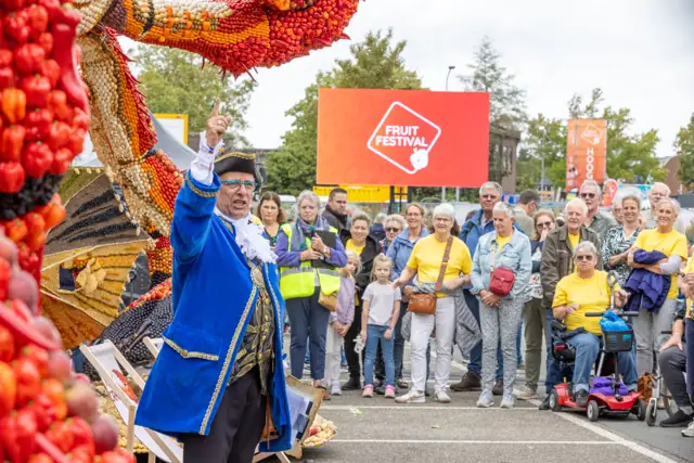 Artiest in blauw kostuum bij het publiek