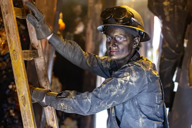 Straatartiest als bronzen mijnwerker