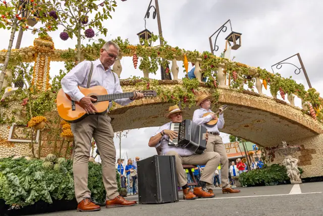 Twee muzikanten spelen voor een fruitkunstwerk